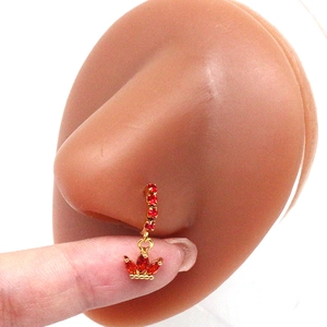 Detail of gold nose hoop with marquise red crystals and a swinging crown pendant