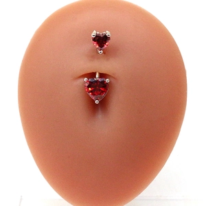 Détail du piercing de nombril en forme de cœur avec zircon rouge sur modèle silicone