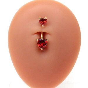 Détail d'un piercing de nombril coeur rouge en zircon sur un modèle de peau