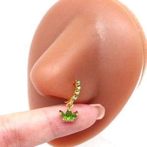 Detail of gold nose ring with green gemstones shown on model for size and fit