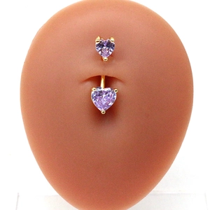 Vue détaillée du piercing de nombril en zircon violet en forme de cœur sur modèle
