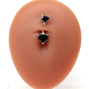 Détail du piercing de nombril avec double cœur en zircone noire sur modèle en silicone