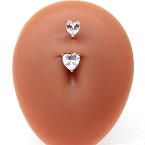 Gros plan d'un piercing de nombril en acier avec zircons blancs en forme de cœur