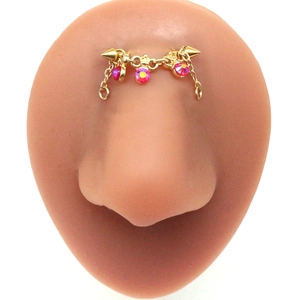 Detail of golden stainless steel nose chain bridge with three pink rhinestones