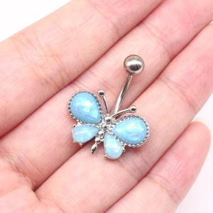 Détail d'un piercing nombril papillon avec ailes en opale bleue et tige en métal argenté