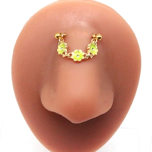 Detail of gold chain septum ring with yellow flower charms and crystals on a nose model