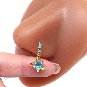 Detail of golden heart Saturn nose ring with light blue crystals on a silicone model