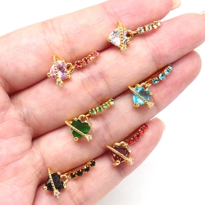 Close-up of heart-shaped planetary stud earrings in gold plating with colorful gems