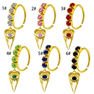 Detail view of heart-shaped gold nose rings with colorful crystals and eye engraving
