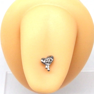 Vue macro d'un piercing de langue coeur en acier inoxydable avec gravure Fuck Me