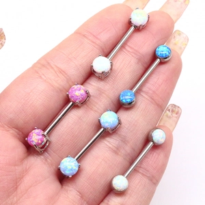 Macro view of stainless steel nipple rings with colorful opal stones held in hand