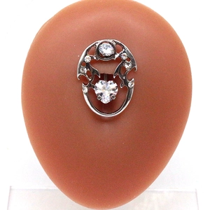 Macro shot of dolphin heart belly button ring with zircon on a skin-toned model