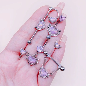 Macro shot of silver body piercing set with purple opal hearts and zircon details