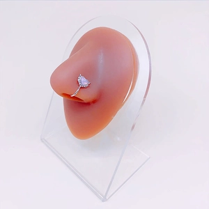 Silver heart nose ring with purple stone and white zircons on a silicone nose model