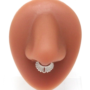 Silver skull nose ring with radial grooved design shown on a silicone nose model