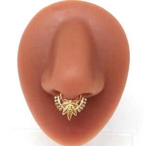 Golden cannabis leaf faux septum nose ring with beaded edges on a silicone nose model
