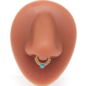 Bohemian gold septum hoop with blue stone and bead detail on a silicone nose model