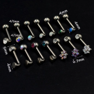 Macro view of G23 titanium body jewelry studs with opal and crystal flower accents
