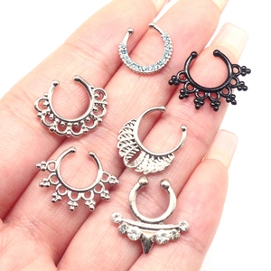 Set of six stainless steel skull and punk style non-pierced septum rings in hand