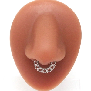 Detailed view of silver non-pierced septum ring with skull hollow design on nose model