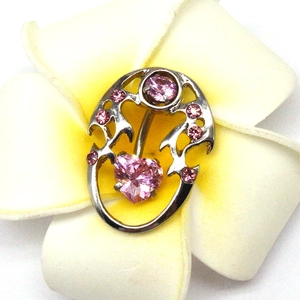 Detail of silver dolphin navel ring with hollow pattern and pink heart zircon stone