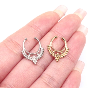 Close-up of gold and silver U-shaped non-pierced nose rings with beaded bohemian details
