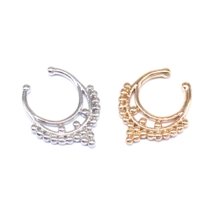 Detail view of gold and silver non-pierced C-shaped nose rings with bohemian grain texture