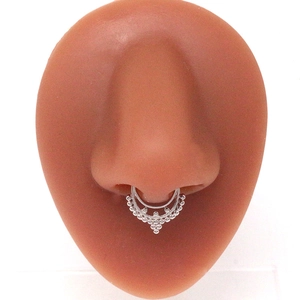 Ethnic style silver layered septum ring with tiny bead details on a nose model