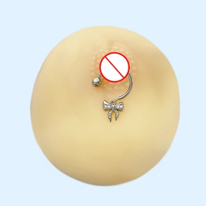 Détail d'un piercing de téton en acier avec nœud en zircone rose sur modèle en silicone