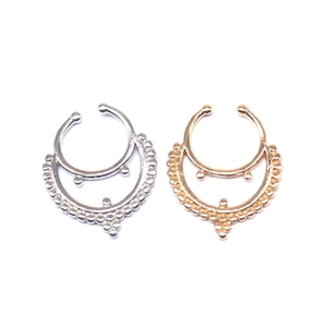 Detailed view of silver and rose gold skull non-piercing septum rings with beads