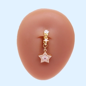 Detail eines goldenen Stern-Bauchnabelpiercings mit Zirkonia auf einem Silikonmodell