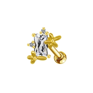 Détail d'un piercing doré avec zircon rectangulaire et motifs floraux ciselés