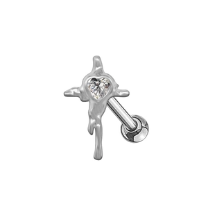 Détail macro du clou d'oreille croix gothique avec zircon cœur et texture liquide