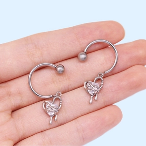 Détail de piercings tétons cœur en forme de fer à cheval avec zircons transparents
