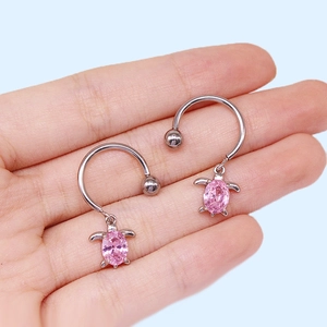 Détail de piercings téton fer à cheval avec pendentifs tortue rose et pierres zircon