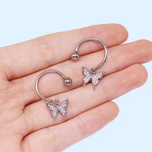 Vue macro de piercings de téton papillon avec zircons roses et fermoirs à vis