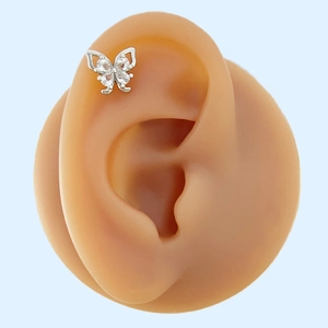 Detailed view of a silver butterfly stud earring with clear zircon wings on an ear model