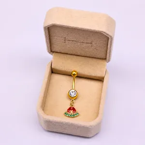 Detalle de un piercing de ombligo dorado con circón y colgante colorido de sandía