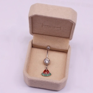 Detalle del piercing de ombligo plateado con cristal y colgante de sandía brillante