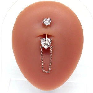 Detalle de piercing de ombligo de corazón con circonita y cadena en modelo de silicona