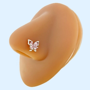 Vista macro del piercing al naso a farfalla argento con cristalli rosa su modello