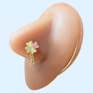 Detail of gold clover nose stud with pink heart zircon on skin-tone model