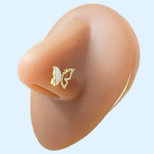 Detailed close-up of golden butterfly nose stud with seashell wing and zircon inlay