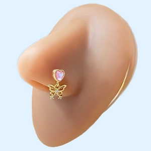 Close-up of gold nose stud with pink heart and butterfly charm on a silicone nose model