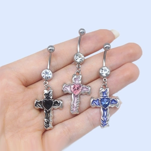Vue détaillée des piercings de nombril croix et cœur en noir, rose et bleu cristal