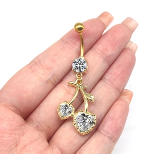 Detail eines goldenen Bauchnabelpiercings Kirsche mit herzförmigen Zirkonia-Steinen