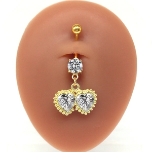 Makro-Detail eines herzförmigen Gold-Bauchnabelpiercings mit Zirkonia auf Silikonmodell
