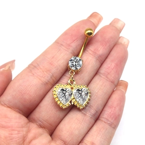 Nahaufnahme von goldenem Bauchnabelpiercing mit runden und doppelt herzförmigen Zirkonia