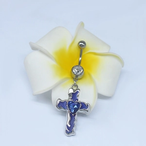 Détail macro du piercing de nombril croix avec émail violet et gemme cœur bleu