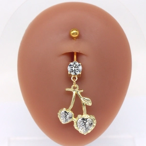 Makro-Detail des goldenen Kirsch-Bauchnabelpiercings mit herzförmigen Zirkonia-Steinen